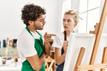 Paint teacher man teaching to student woman at art studio.