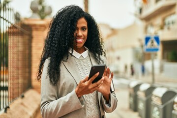 Middle age african american businesswoman using smartphone at the city.