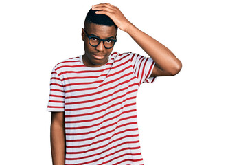 Young african american man wearing casual t shirt and glasses confuse and wonder about question....