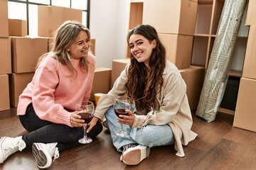 Young couple smiling happy toasting with red wine at new home