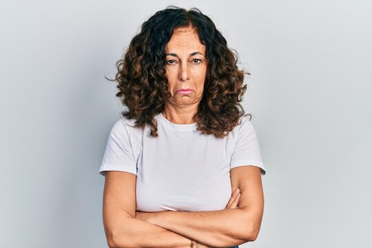 Middle age hispanic woman with arms crossed gesture depressed and worry for distress, crying angry and afraid. sad expression.