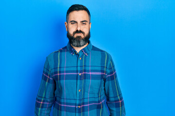 Young hispanic man wearing casual clothes puffing cheeks with funny face. mouth inflated with air,...
