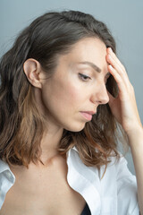 Naklejka premium Model, brunette close-up. in a studio. She is wearing a white shirt, a black hairstyle.