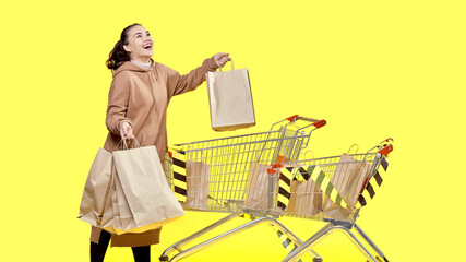 Black Friday, a happy girl with shopping in her hands is standing at the shopping cart