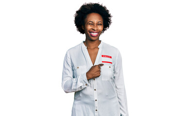 African american woman with afro hair wearing hello my name is sticker identification winking looking at the camera with sexy expression, cheerful and happy face. © Krakenimages.com