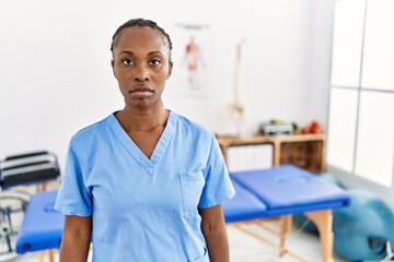 Black woman with braids working at pain recovery clinic relaxed with serious expression on face. simple and natural looking at the camera.