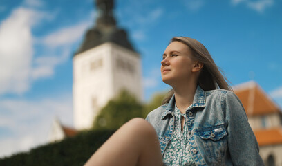 Woman resting against church in old Tallinn.