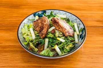 Rocket salad, seeds, apple and tomato chunks, balsamic vinegar and fried chicken wings