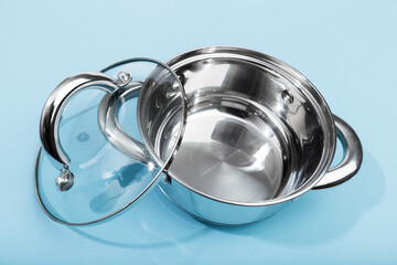 steel pan with a transparent lid on blue background .