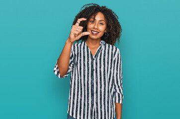 Young african american girl wearing casual clothes smiling and confident gesturing with hand doing...