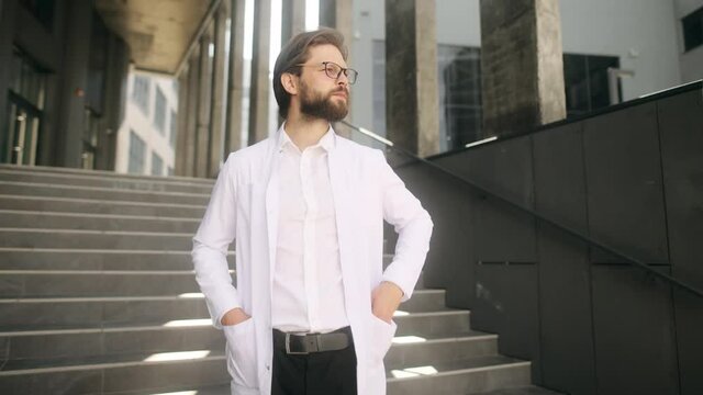 Close-up portrait of nice-looking handsome young medical worker looking into camera. Successful people. High quality 4k footage