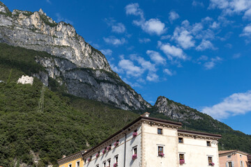 Fototapeta na wymiar Residential houses in Italian town Riva del Gardo with blue sky and Monte Rocchetta in the background