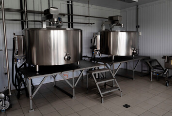 Fototapeta na wymiar Interior of cheese factory with fermentation tank. Technology equipment at cheese farm. 