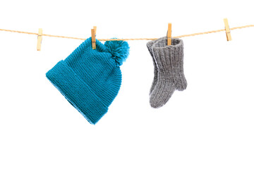 Baby clothes on a clothesline on white  background . knitted sock and cap