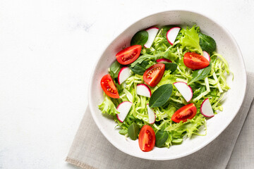 Bowl with vegetarian fresh salad. Healthy food, diet lunch. Top view on a white background.