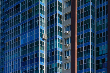 Obraz premium Windows and balconies of the residential building. A modern apartment building on the outskirts of a Russian city.