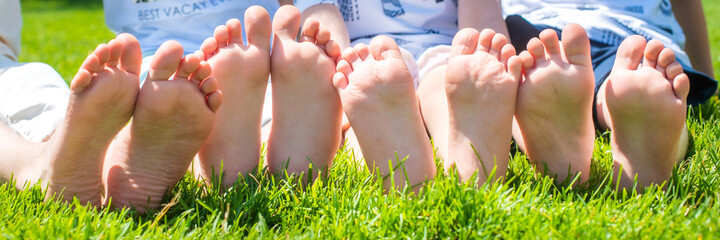 baby bare legs in the frame. barefoot on the grass brother and sister. four. wrinkled. fun together