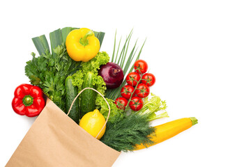 A set of vegetables and herbs in a paper bag isolated on white background. Concept: Shopping in a supermarket or market and Healthy Vegetarian Food.