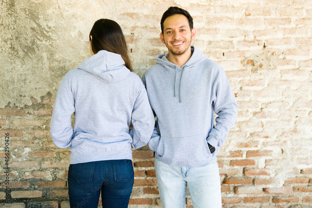 Wall mural good-looking woman and man in hoodies