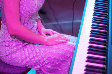 a musician girl is sitting near the piano