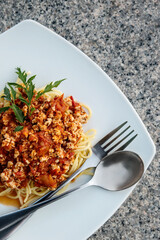 Italian pasta bolognese served on granite tabletop, copyspace. Top view, close up