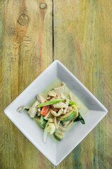 Green curry with chicken on wooden background. Traditional thai food