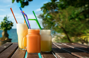 Set of fresh fruit cocktails on tropical island with sea view background