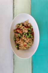 Asian spicy minced meat on wooden background. Thai hot minced pork salad. Traditional Thailand food. Pad Krapow Gai, Pad Kra Pao, Pad Krapow. Copyspace
