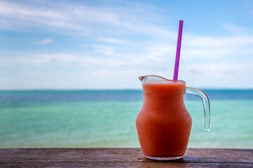 Fresh fruit cocktails on tropical island with sea view background.