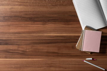 TOP VIEW OF OFFICE SUPPLIES ON A WOODEN TABLE WORKSPACE. COPY SPACE. NOTEBOOKS, NOTES, PAPER