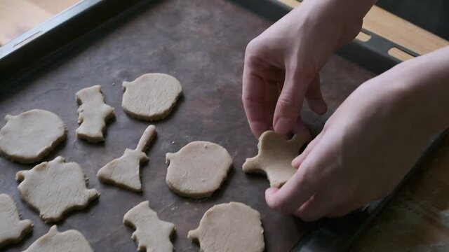 Woman's hands making cookies from dough to halloween