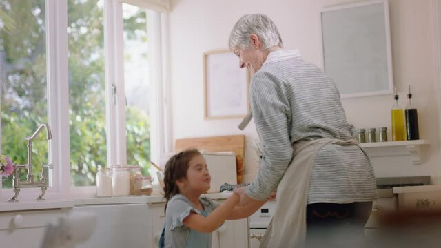 happy grandmother dancing with little girl in kitchen granny having fun dance with granddaughter celebrating family weekend at home