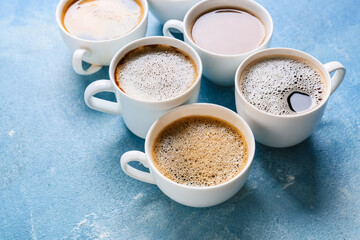 Cups of tasty coffee on color background