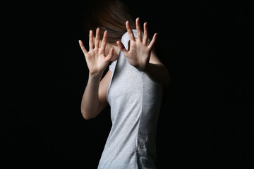 Scared young woman on dark background. Concept of harassment