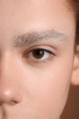 Fototapeta premium Teenage boy with dyed eyebrows on color background, closeup