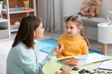 Fototapeta premium Speech therapist working with cute girl in clinic