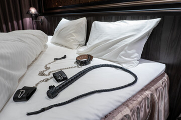 ベッドに置かれた鞭と首輪と足枷　SMプレイのイメージ　whip and collar on the bed	