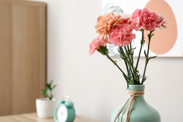 Vase with beautiful carnations in room