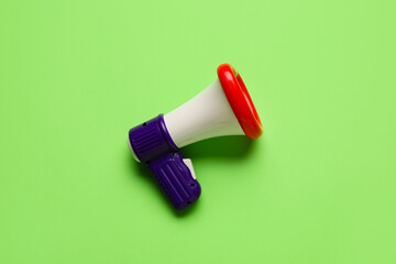 Toy megaphone on green background