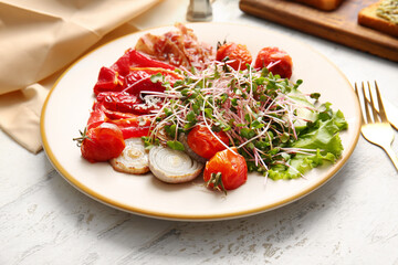 Plate of tasty salad with vegetables, fried bacon and micro green on light background