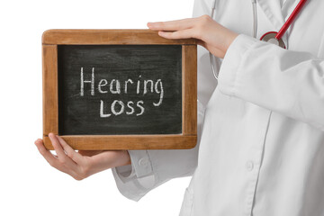 Female doctor holding board with text HEARING LOSS on white background