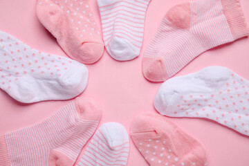 Obraz na płótnie Canvas Frame made of different baby socks on color background, closeup
