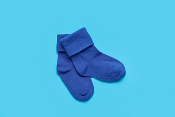 Baby socks on color background