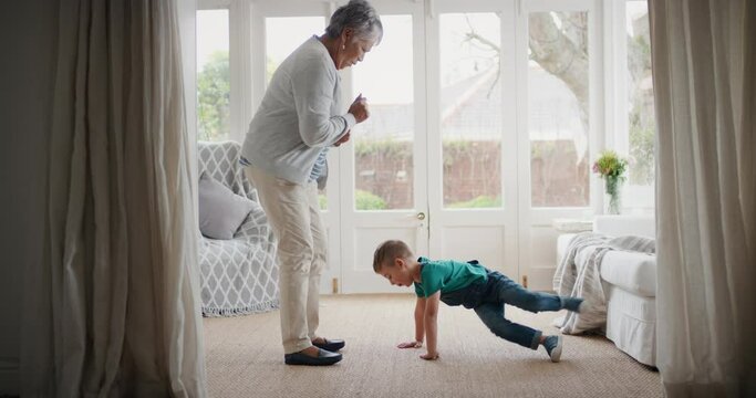 happy little boy dancing with grandmother funny granny having fun dance with grandson celebrating family weekend at home