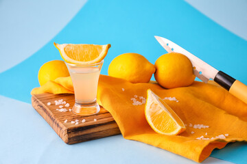 Shot of tasty tequila with lemon on color background
