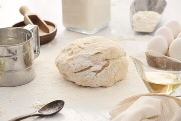 Fresh dough and ingredients on light kitchen table