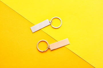 Stylish keychains on color background