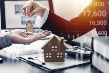 Agents or Dealer delivers keys is the new home to a customer, deal mortgage, real estate developer, Stock market or forex trading, analysis graph candlestick chart, financial investment concept.