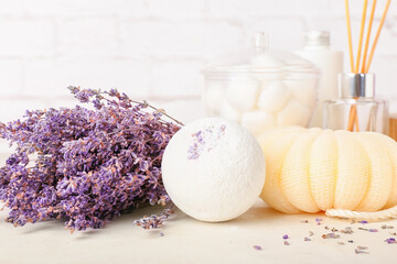 Set of bath supplies and lavender flowers on light background