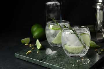 Glasses of cold gin and tonic on dark background